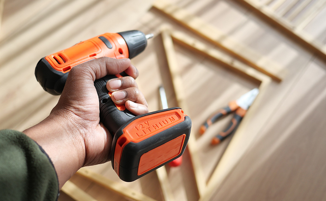 person holding a drill for a home improvement project